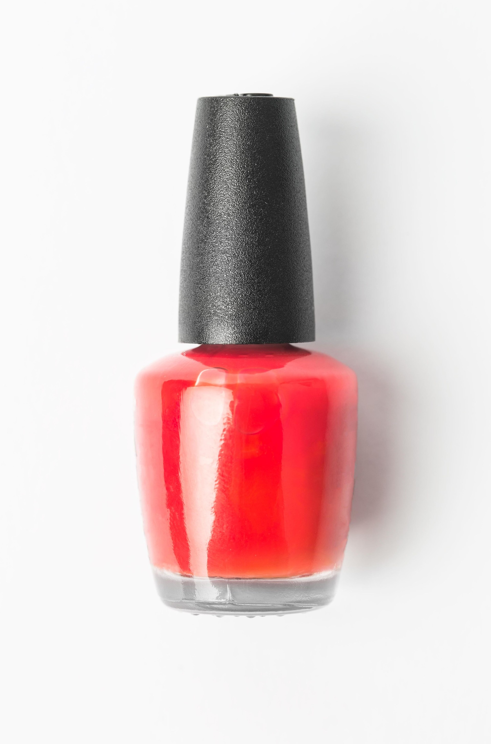 Red nail polish bottle isolated on white background