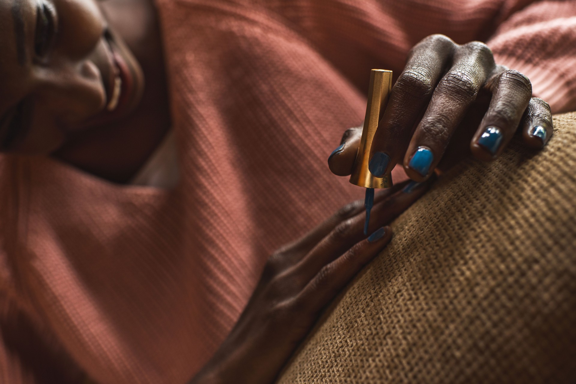 Close up of African American woman doing her nails.